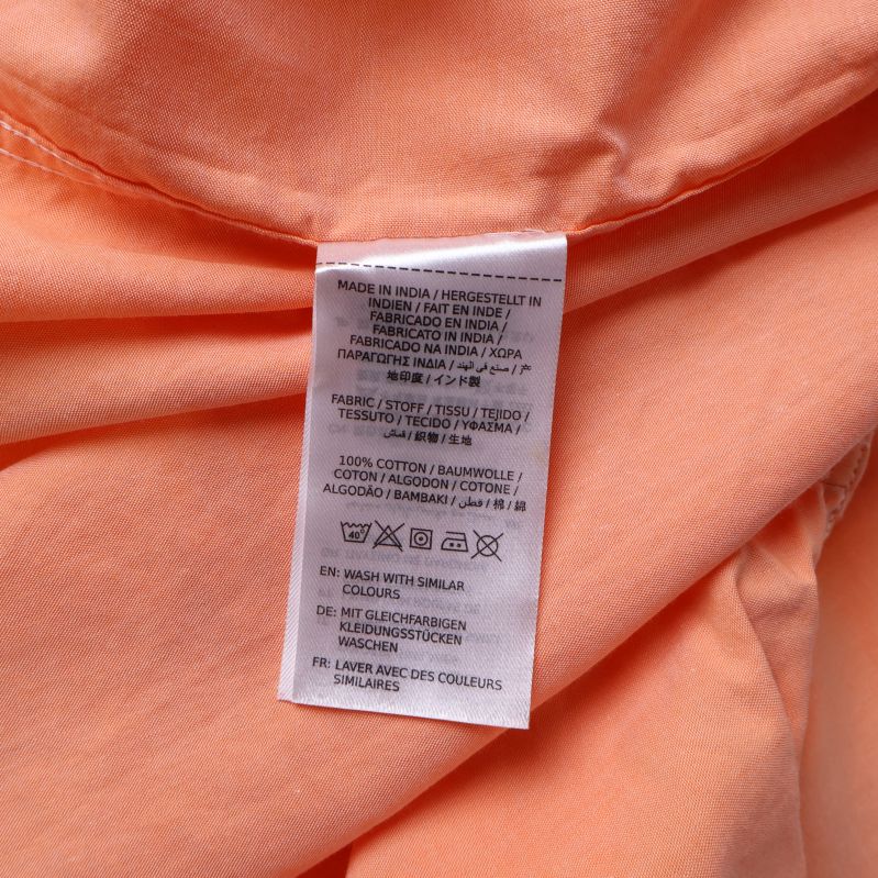 Materiallapp visar 100% bomull inuti skjorta