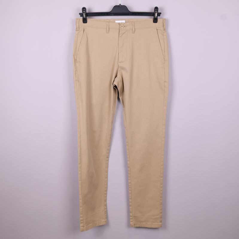Beige chinos upphängda framifrån med raka ben