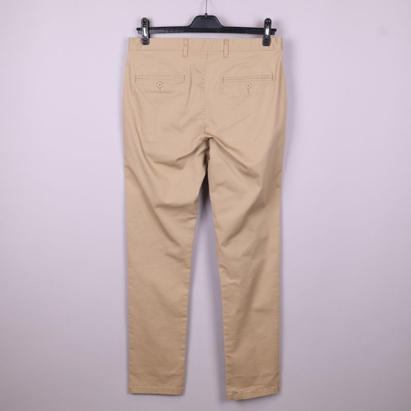 Baksidan av beige chinos med fickor och knappar
