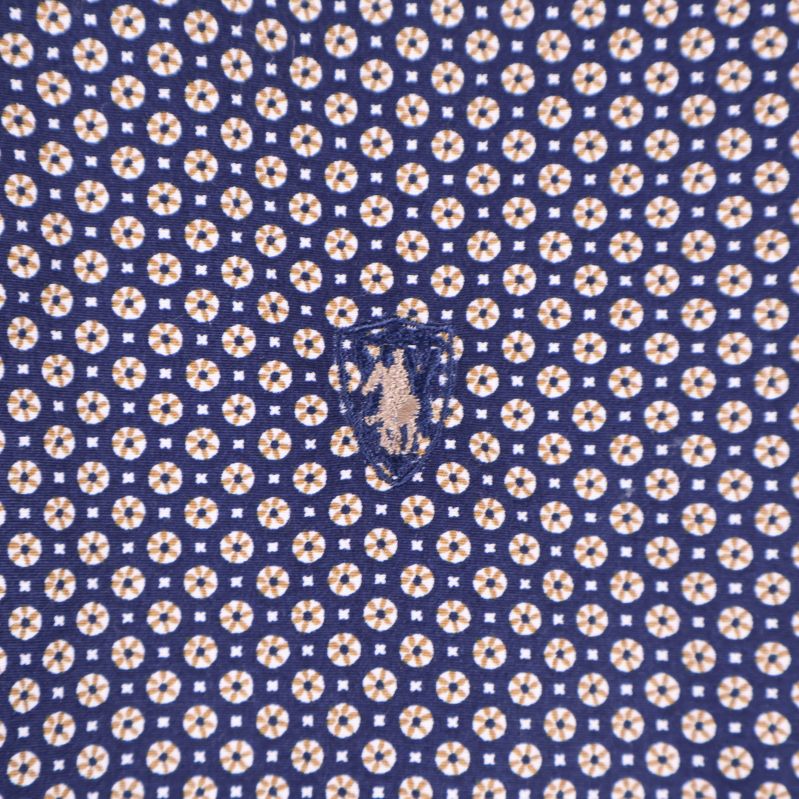 Närbild av broderad logotyp och cirkulärt mönster