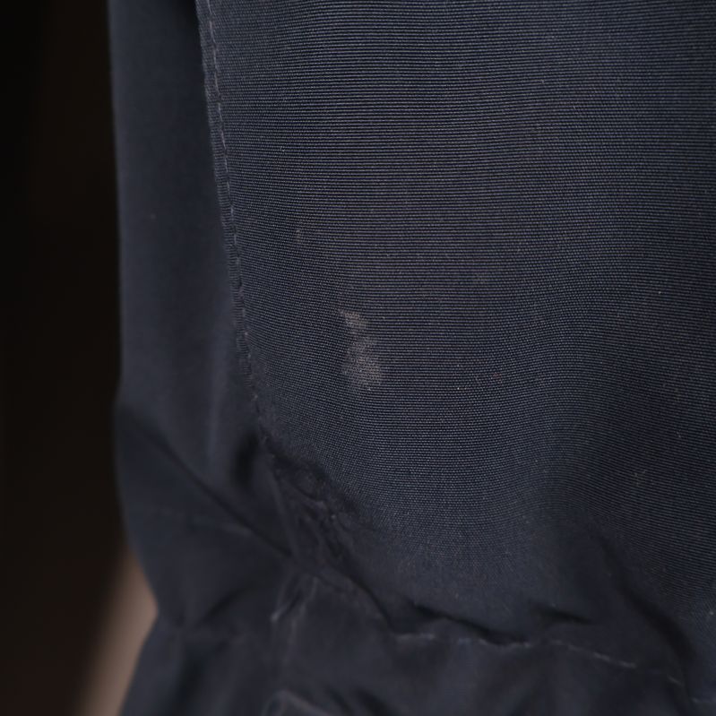 Närbild av mindre fläck på mörkblå parkas