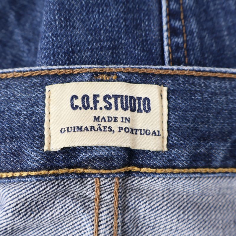 Vit etikett med C.O.F Studio logotyp 