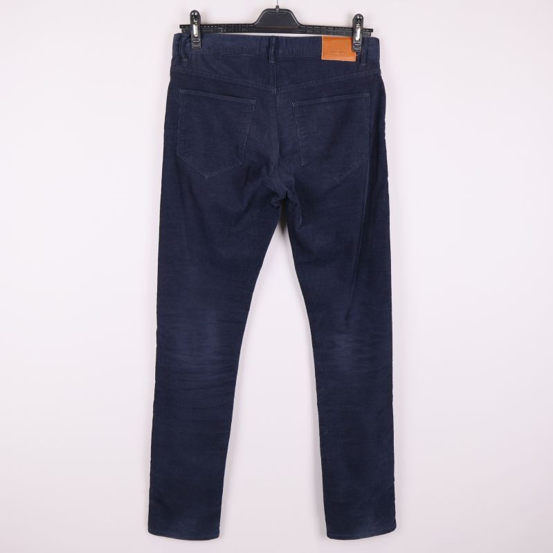 Baksida av mörkblå manchesterbyxor med två bakfickor