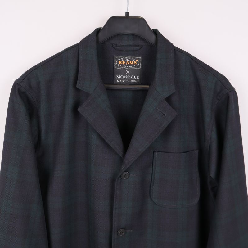 Halvnärbild av krage och bröstficka på rutiga kavajen