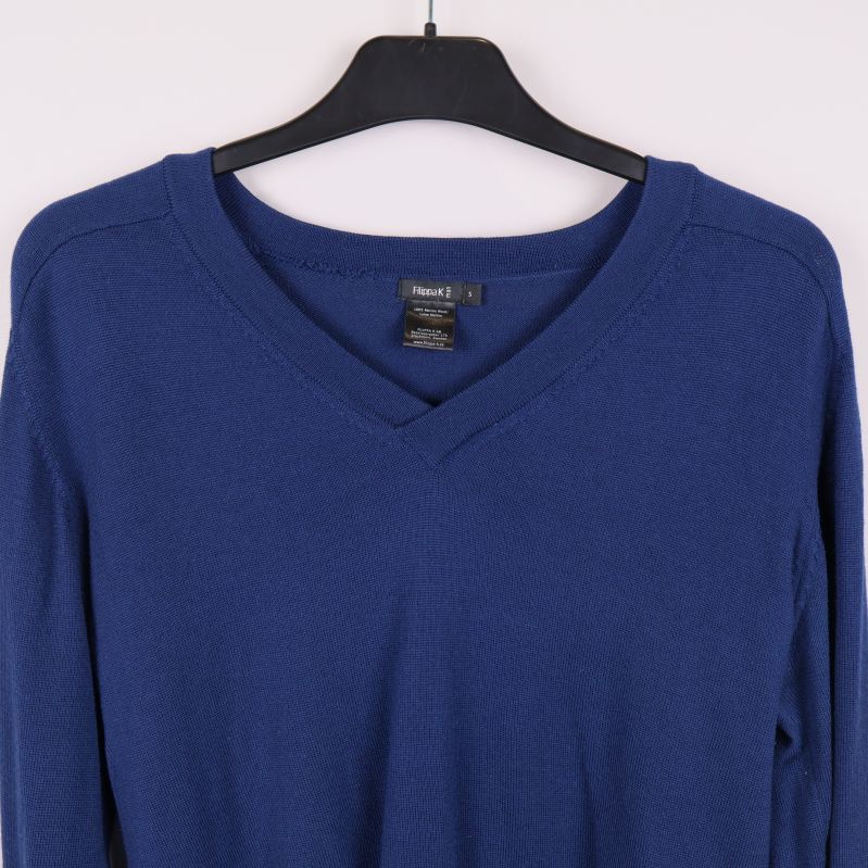 Närbild på v-ringad hals och axel på blå tröja