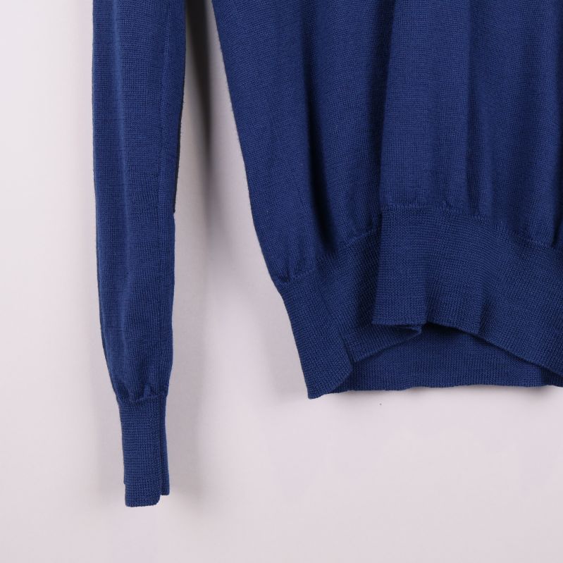 Närbild på avslut vid ärm och midja på blå tröja