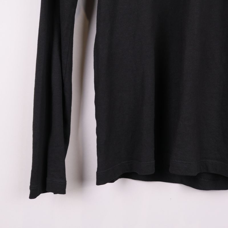 Nederkant och ärmslut på svart långärmad pikétröja