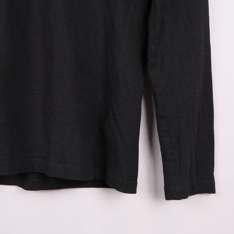 Nederkant och ärmslut på svart långärmad pikétröja