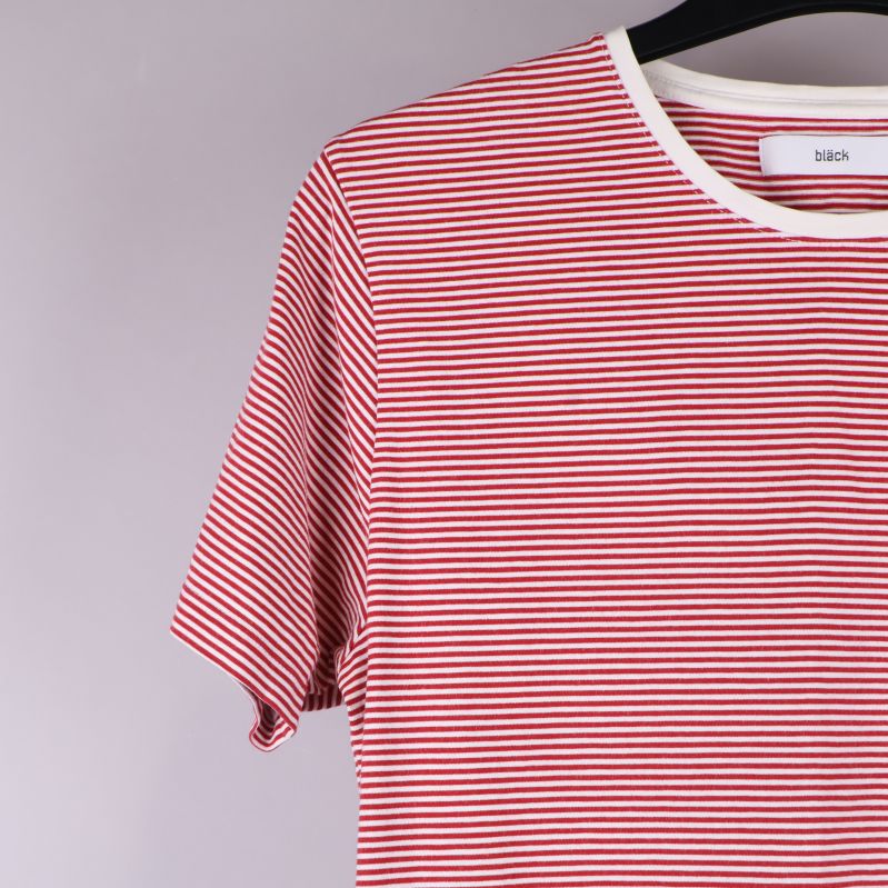 Närbild på ärm och axel av röd- och vitrandig t-shirt