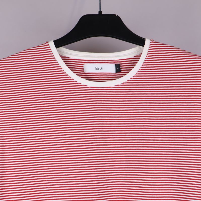 Närbild på halsringning med vit kant och randig t-shirtdesign