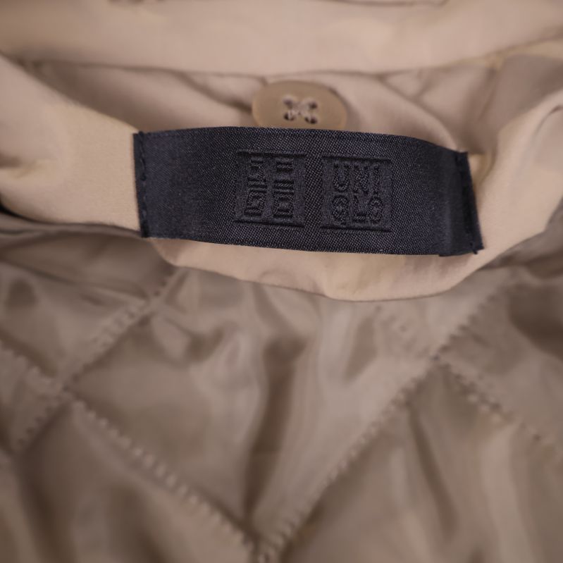 Uniqlo märkesetikett i svart på insidan av jackan