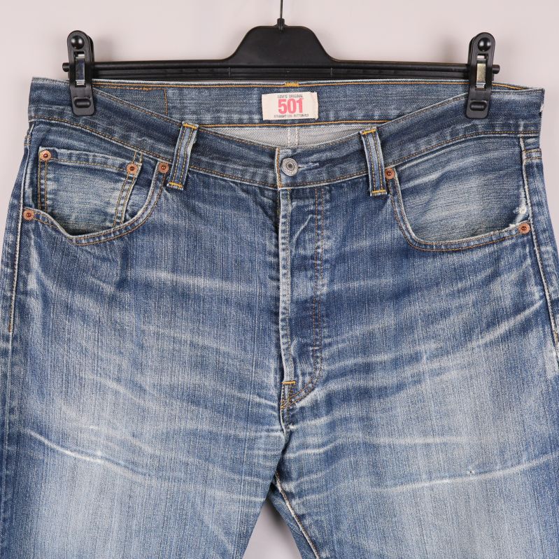 Framsidan upptill av jeansen med knappgylf