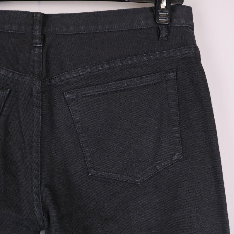 Närbild på bakficka och linning på svarta jeans