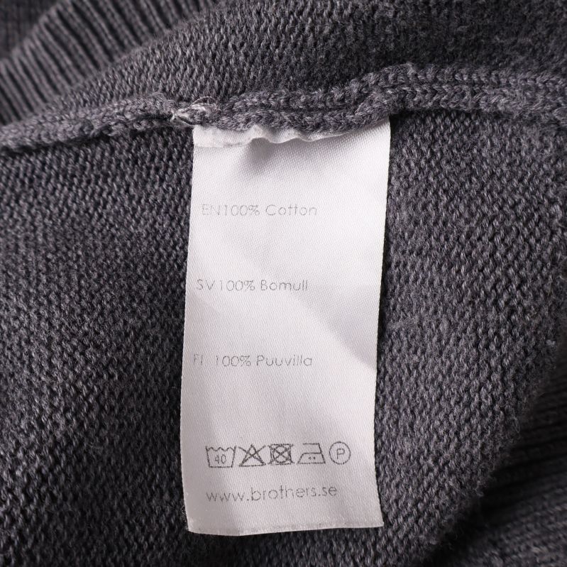 Materiallapp som visar 100% bomull och tvättråd