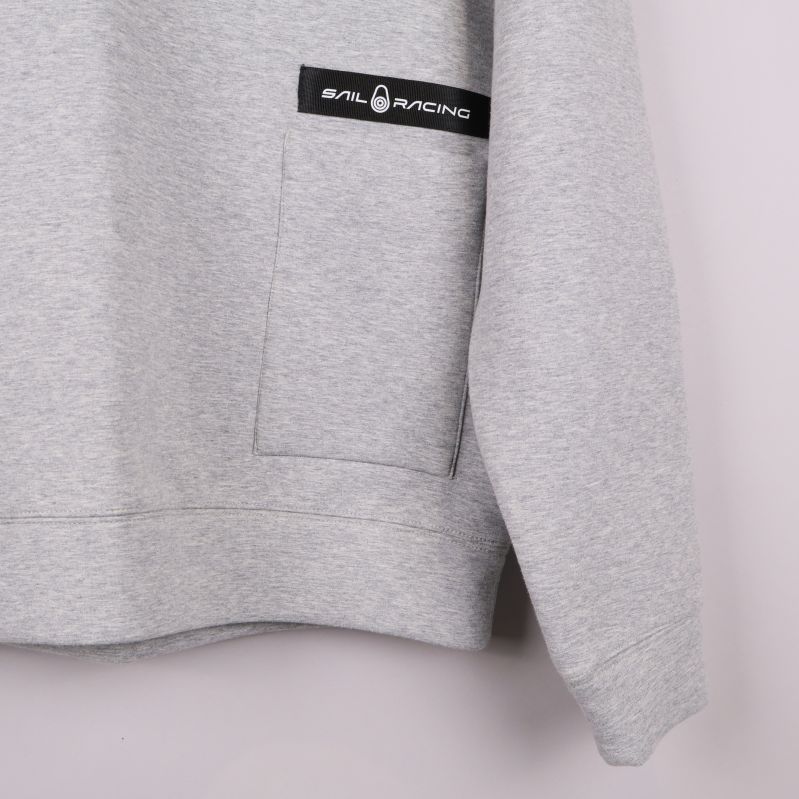 Stor framficka på sweatshirt med Sail Racing-logo ovanför