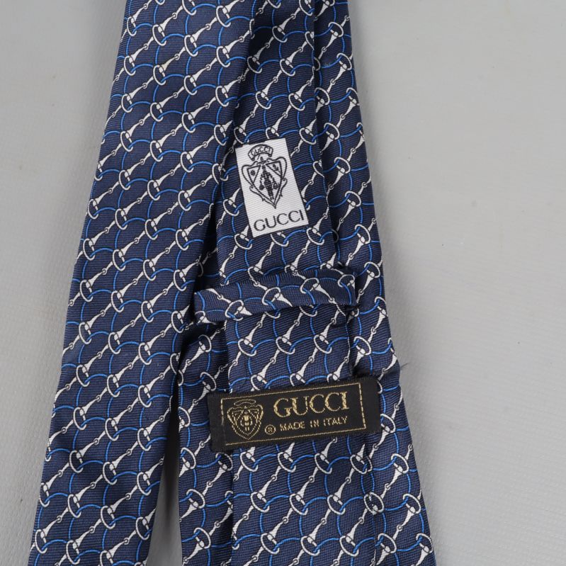 Närbild av slipsens baksida med GUCCI etiketter
