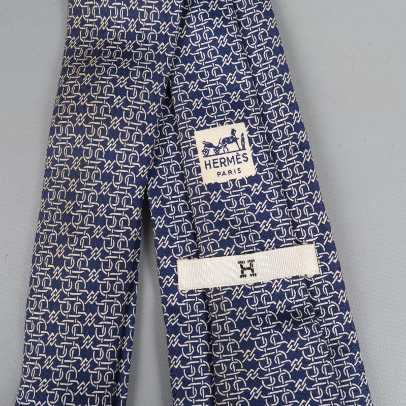 Närbild på Hermès logotyp och mönster på slipsen