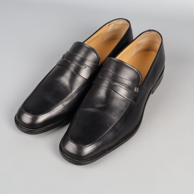 Svarta loafers med pennydetalj i sidan, sidovy