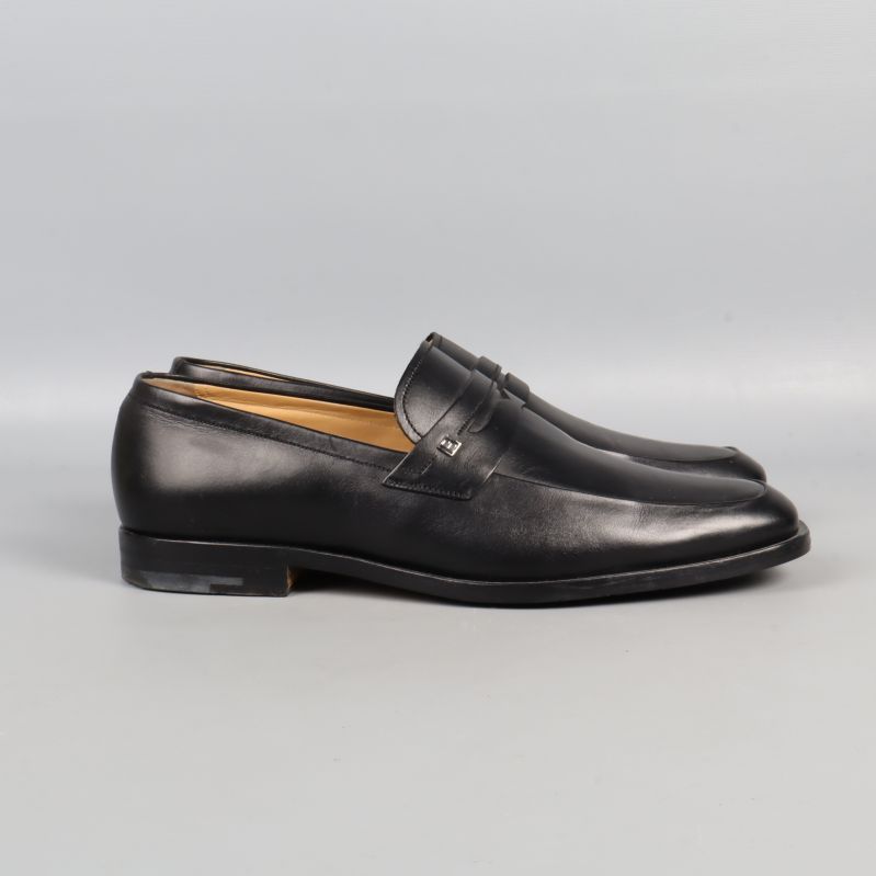 Svarta loafers fotograferade från sidan på ljus bakgrund
