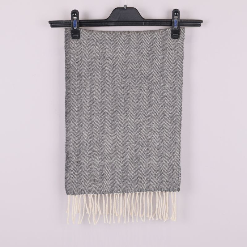 Grå halsduk med fiskbensmönster och fransar hängande rakt ner