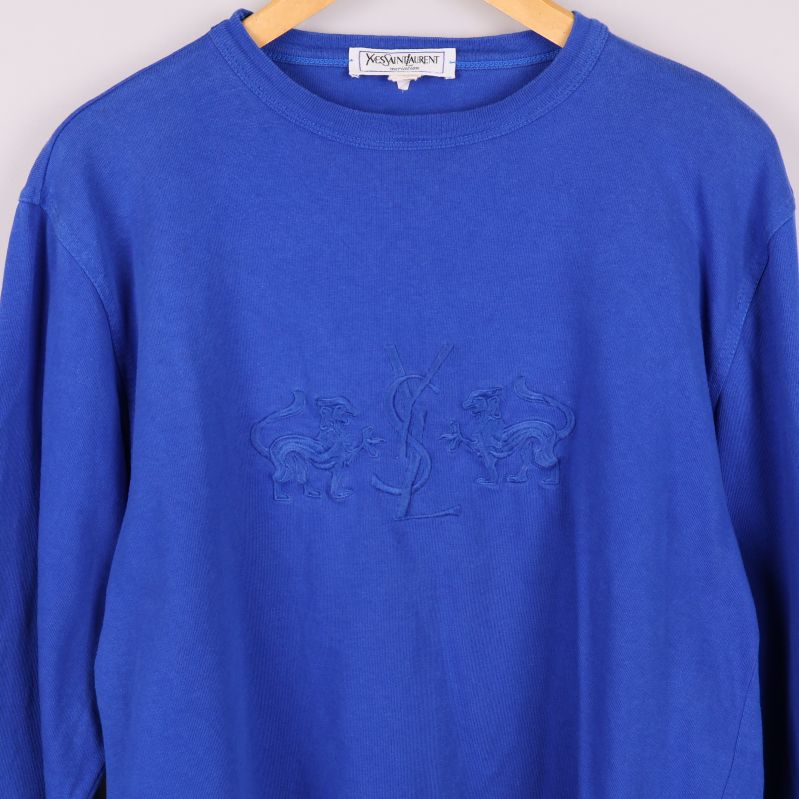 Närbild på broderad logotyp på tröjans bröst