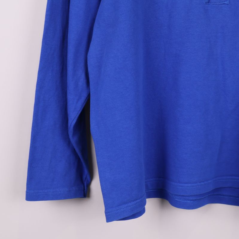 Närbild på ärmslut och nederkant av blå tröja