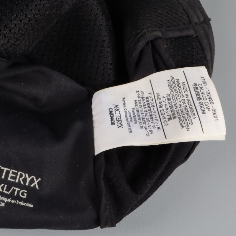 Närbild av materialetikett i svart keps