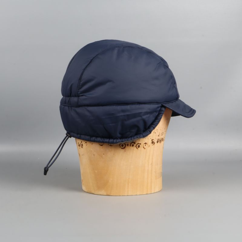 Blå vadderad keps med öronlappar från vänster sida