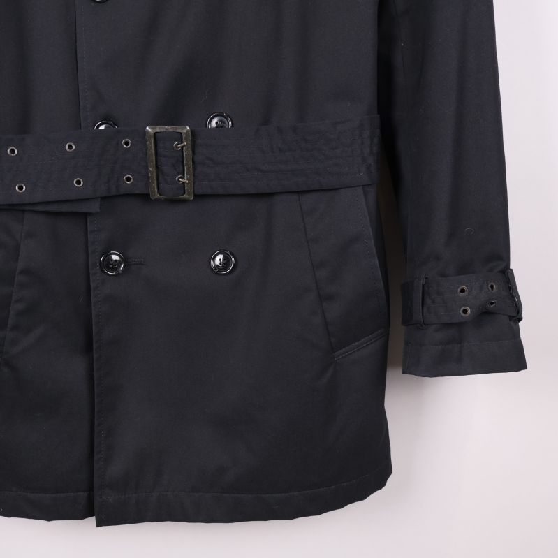 Detaljbild på ficka och ärmslut med spänne på trenchcoat