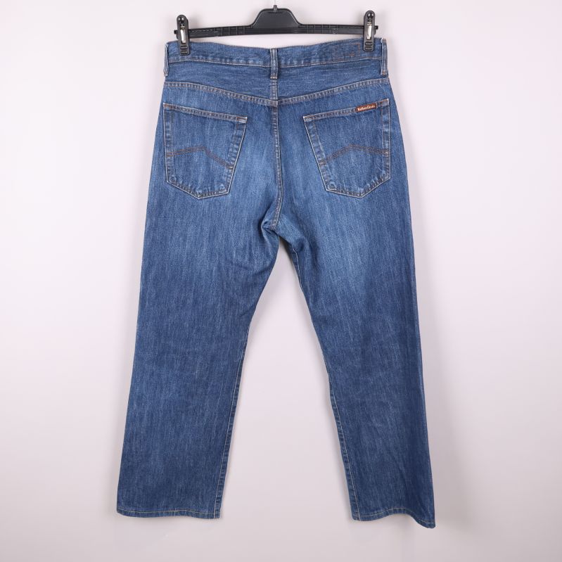 Blå jeans bakifrån med två bakfickor och label