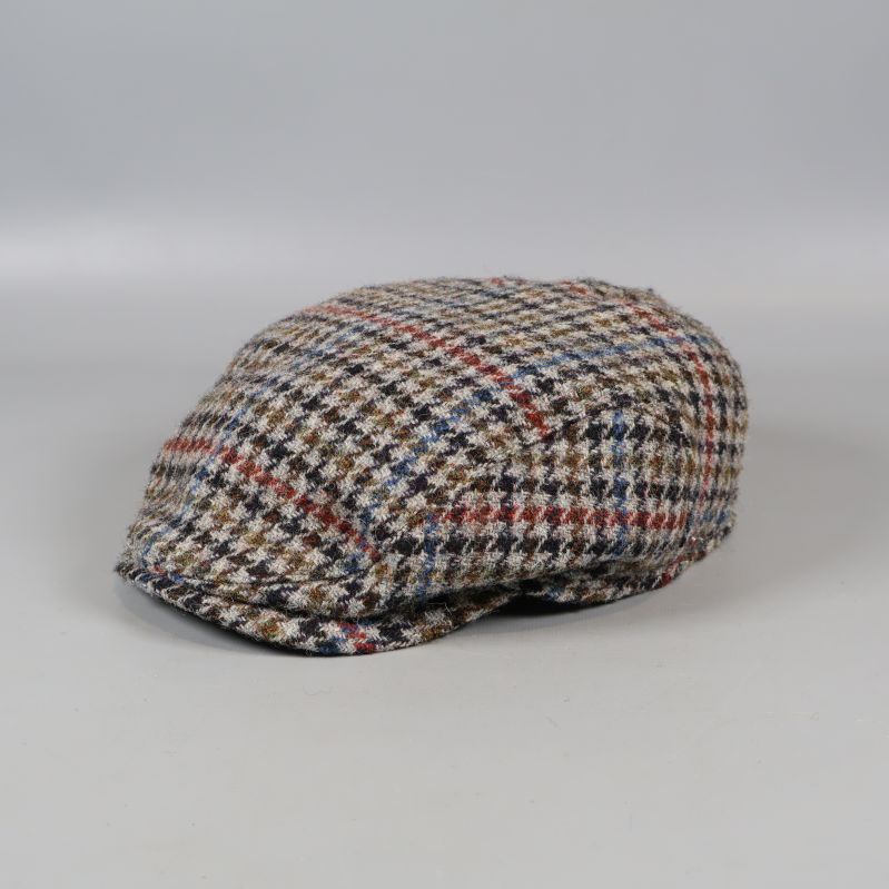 Rutigt keps i fiskbensmönster på ljus bakgrund