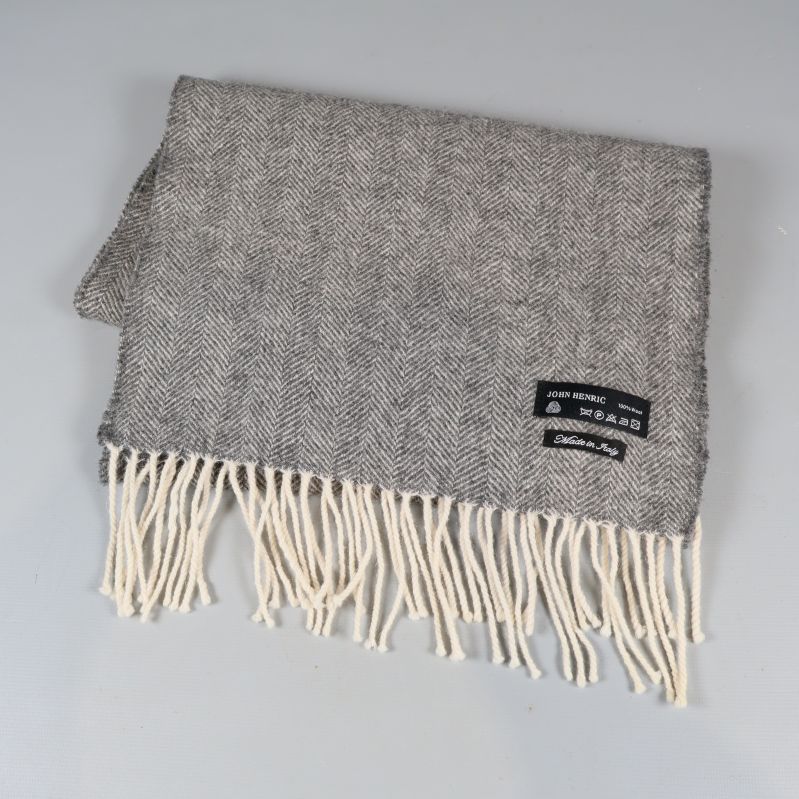 Grå halsduk viks ihop, etiketter och fransar synliga