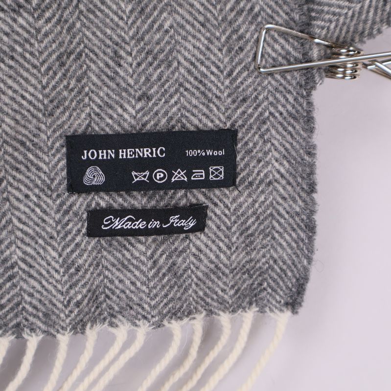 Närbild av etikett på John Henric halsduk, 100% wool