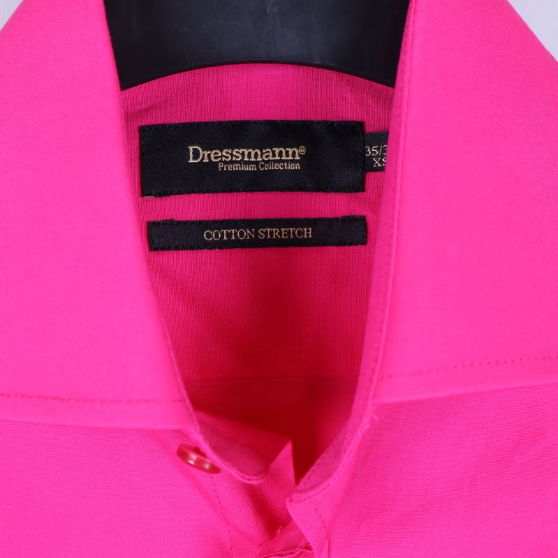 Närbild på krage och Dressmann-etikett på kritrosa skjorta