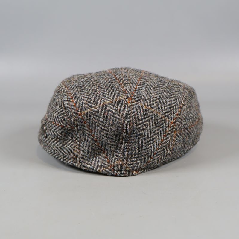 Baksida på fiskbensmönstrad tweedkeps med synliga detaljer