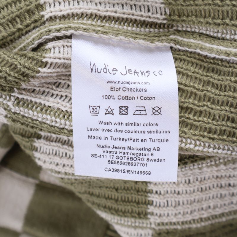 Material- och tvättetikett från Nudie Jeans Co visar 100% bomull
