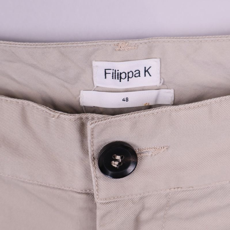 Detaljbild på Filippa K-logotyp och knapp i midjan