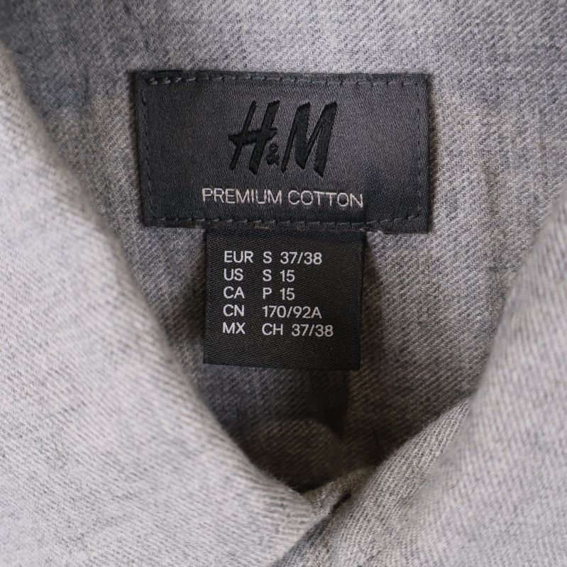 Närbild på H&M premium cotton etikett i kragen