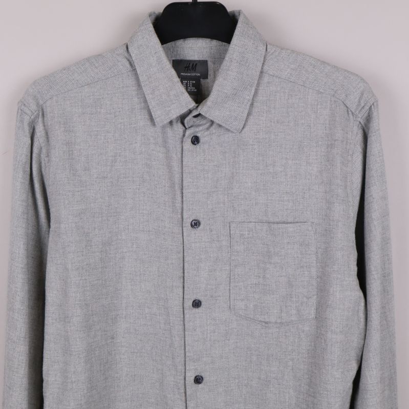 Framdel av grå skjorta med krage och knappslå