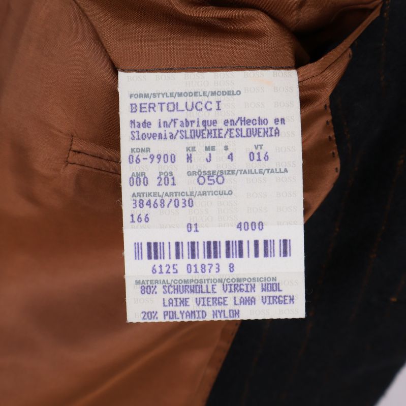 Tvättrådsetikett i kavaj med materialinformation om ull och polyamid