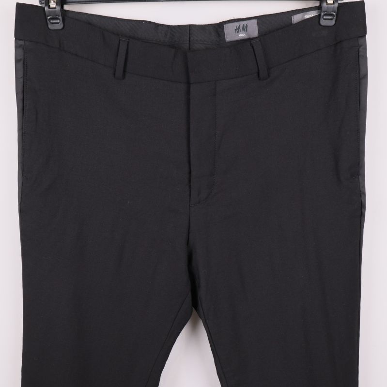 Detalj av midja och gylf på svarta byxor