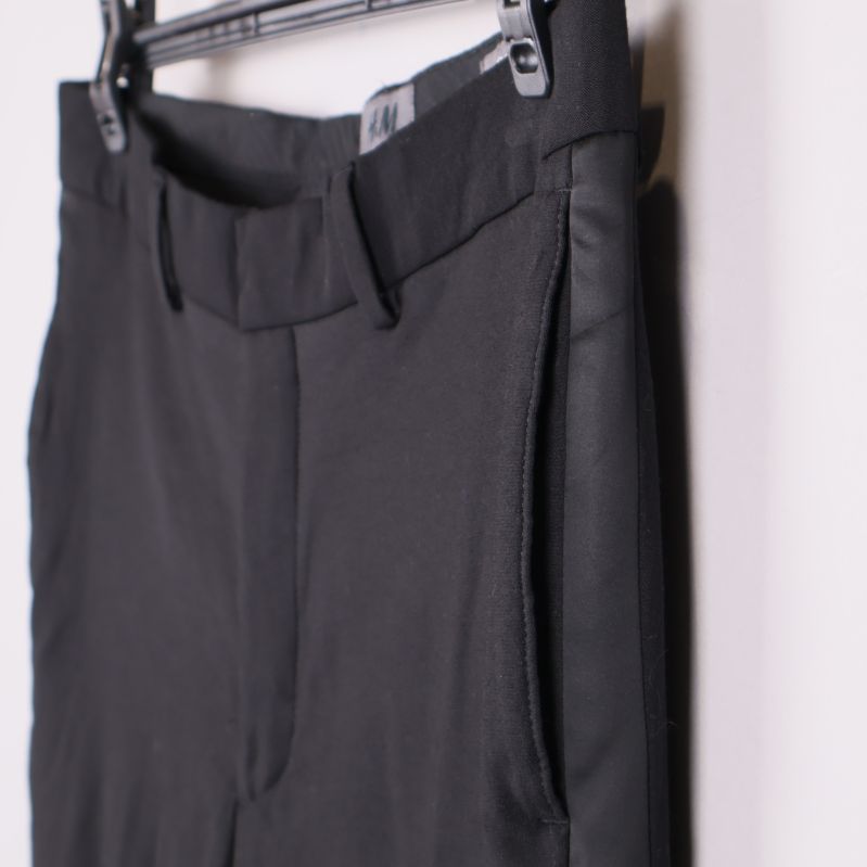 Sidan av svarta skinny fit byxor med ficköppning