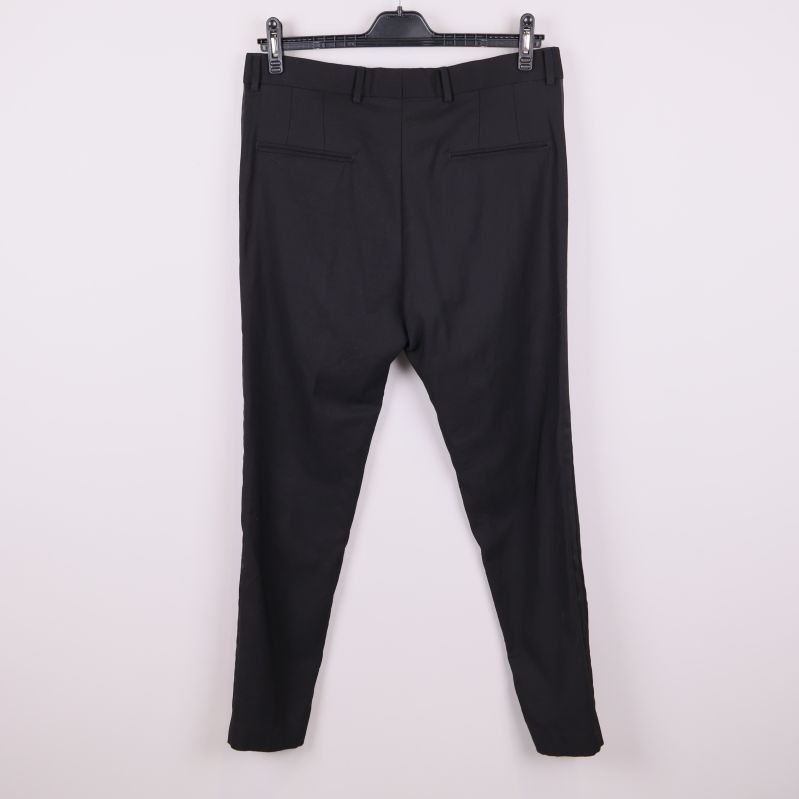 Baksida på svarta kostymbyxor med fickor