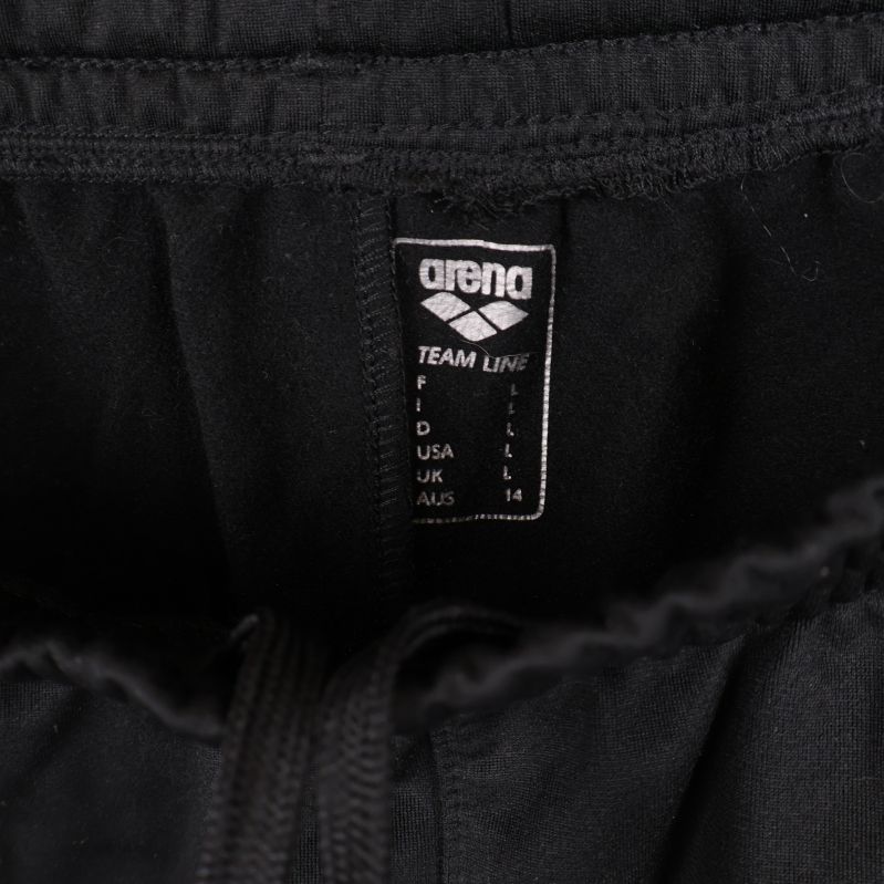 Närbild på Arena-logga och snörning i midjan på byxorna