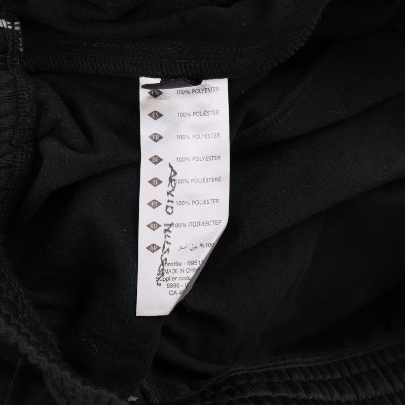 Materiallapp som visar 100% polyester i byxorna