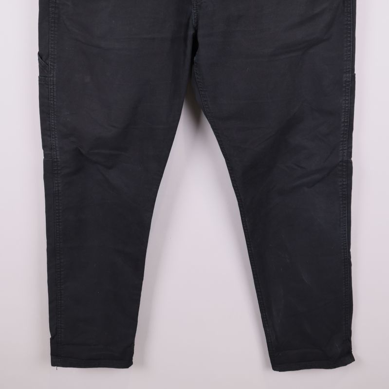 Undre delen av de svarta jeansens ben i detalj