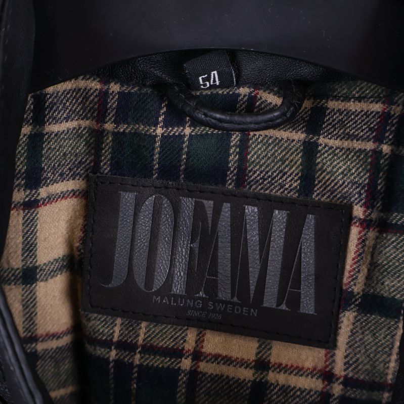 Närbild på Jofama märke i jackans rutiga foder