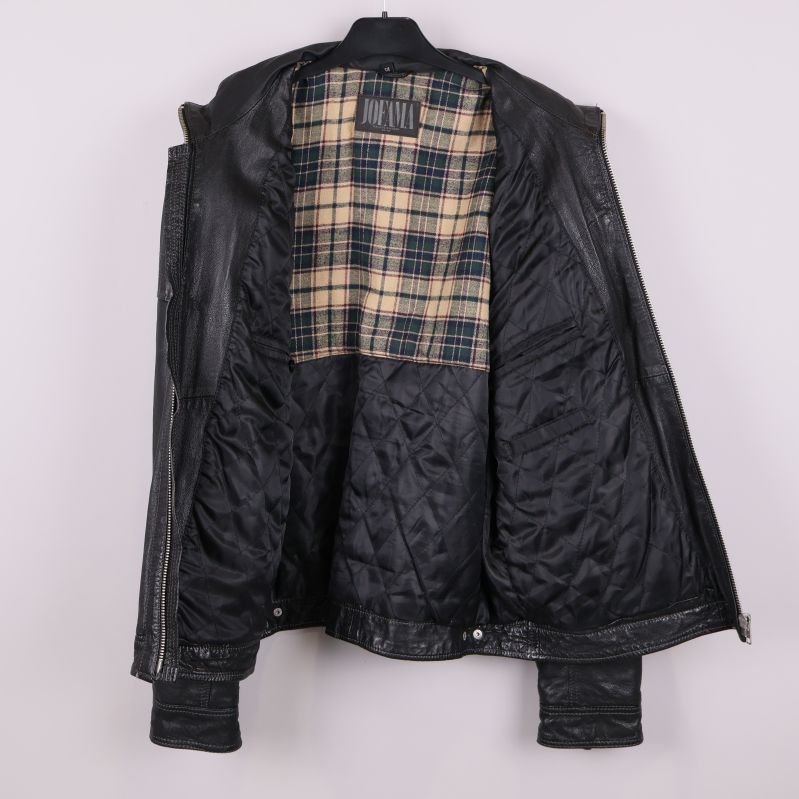 Insida av jackans foder, rutmönster upptill, svart quiltat nedtill