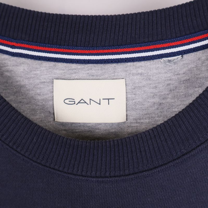 Detalj av GANT-logotyp i nacken på tröjan