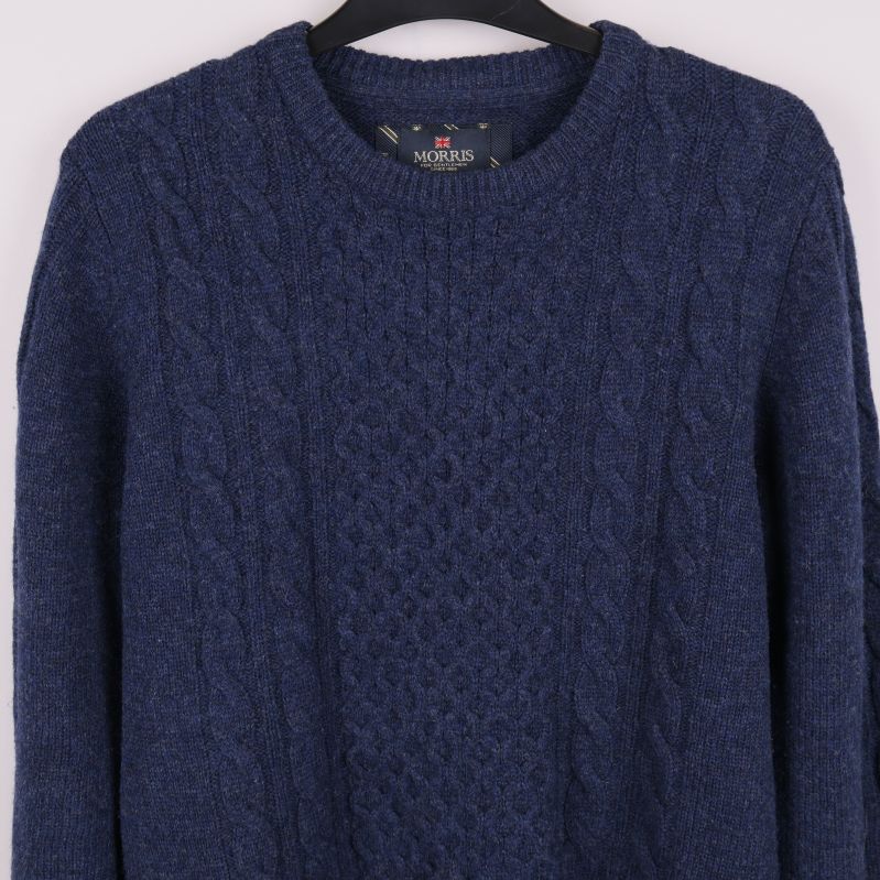 Närbild av tröjans kabelstickade framstycke